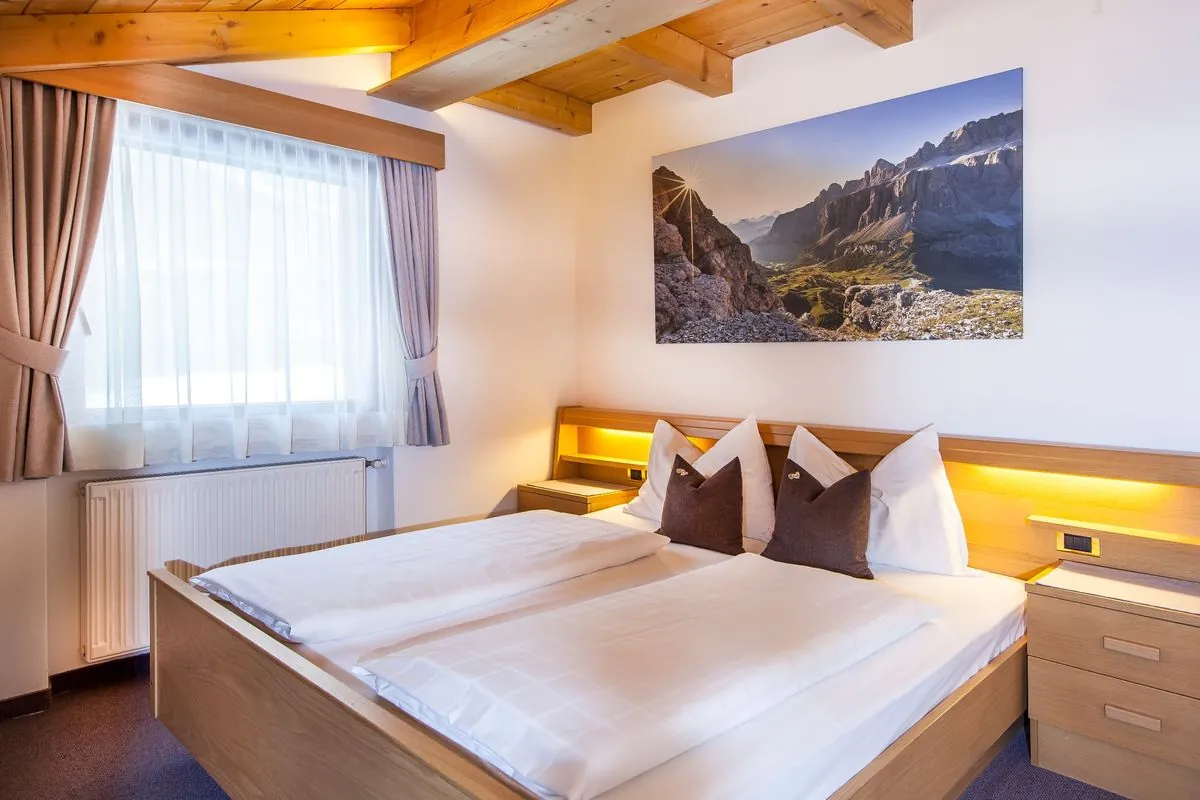 Schlafzimmer in der Dependance mit Bergbild über dem Bett