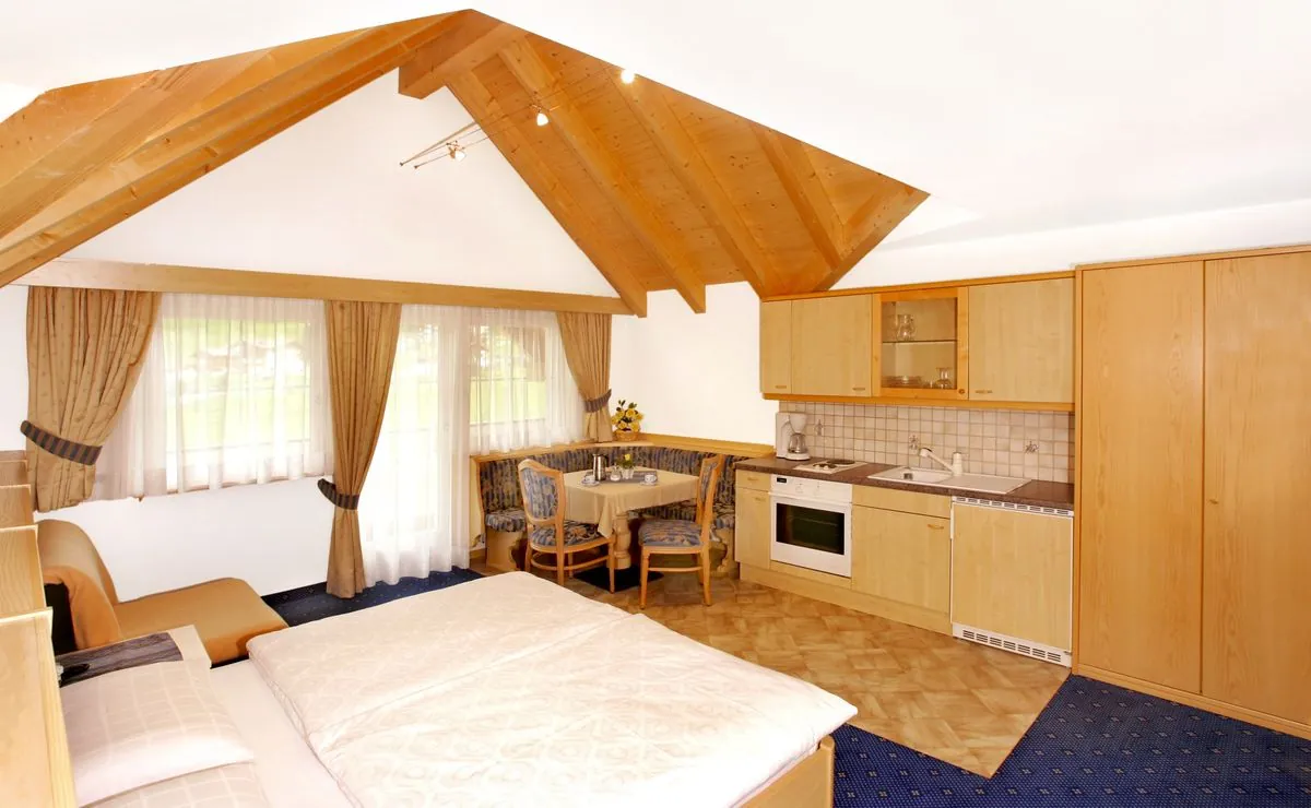 Einzimmerwohnung mit Doppelbett, Sitzecke und Kochnische