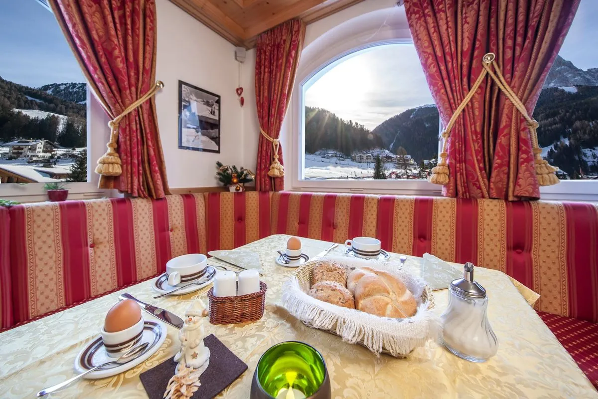 Frühstückstisch am Fenster mit Blick auf die verschneiten Berge
