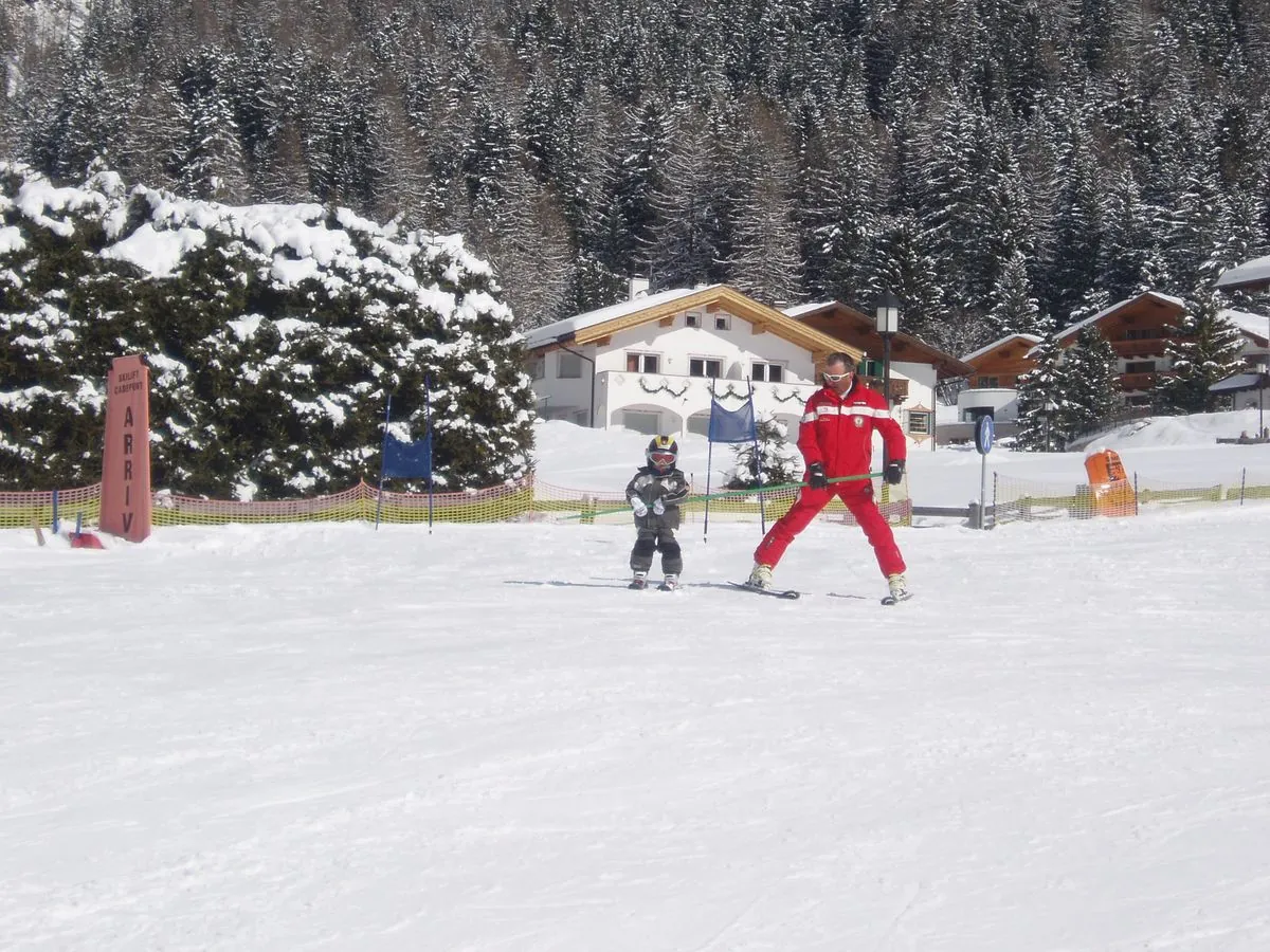 Kind mit Skilehrer am Übungshang