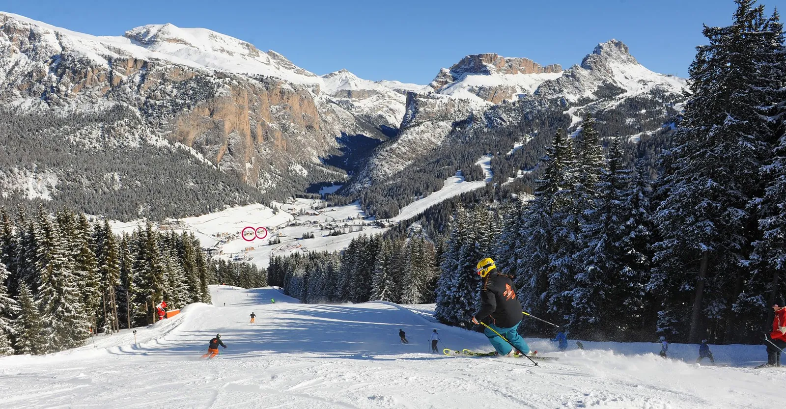 Skifahrer auf dem Ciampinoi, unten im Tal Wolkenstein mit zwei roten Markierungen