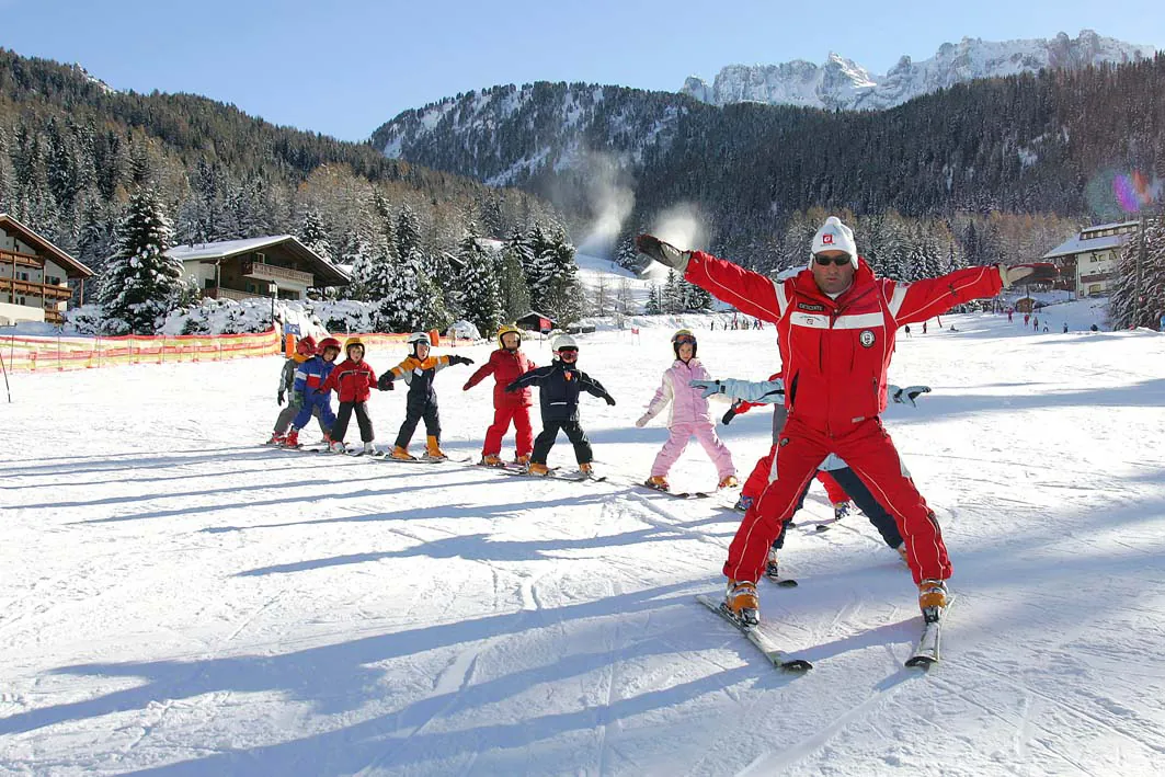 Skilehrer mit einer Kindergruppe auf der Piste