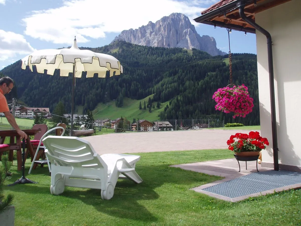 Terrasse mit Sonnenschirm und Blick auf die Dolomiten